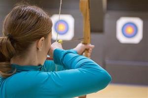 Woman aiming bow at archery targets